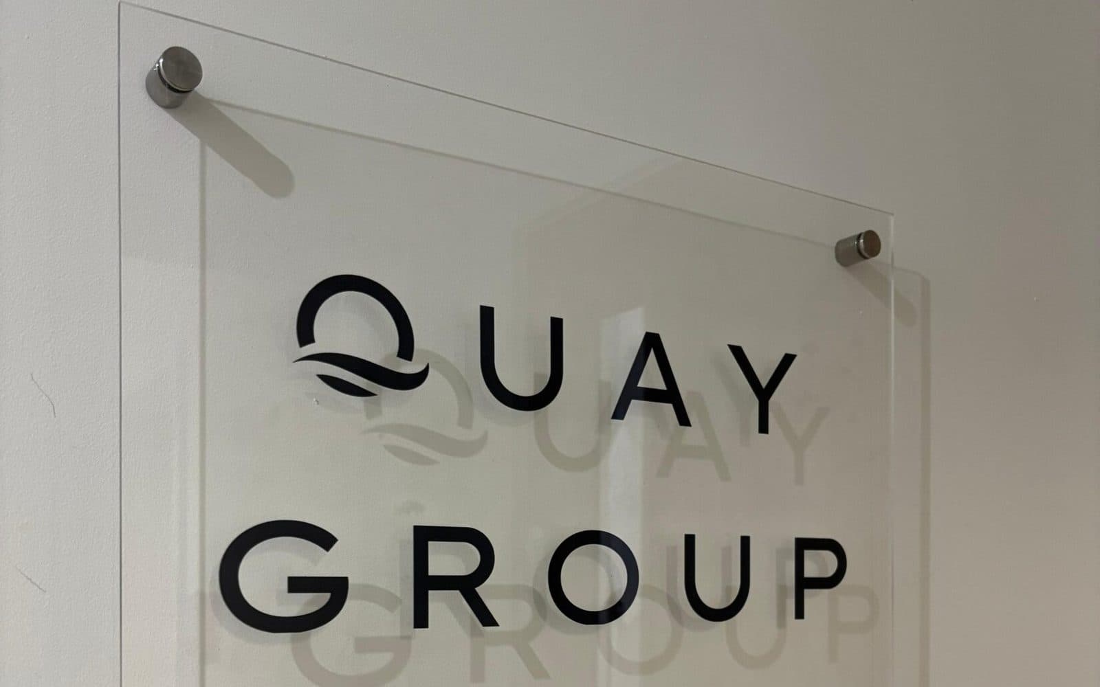 The Quay Group name plaque, printed on clear acrylic, mounted on the wall of the Bournemouth office