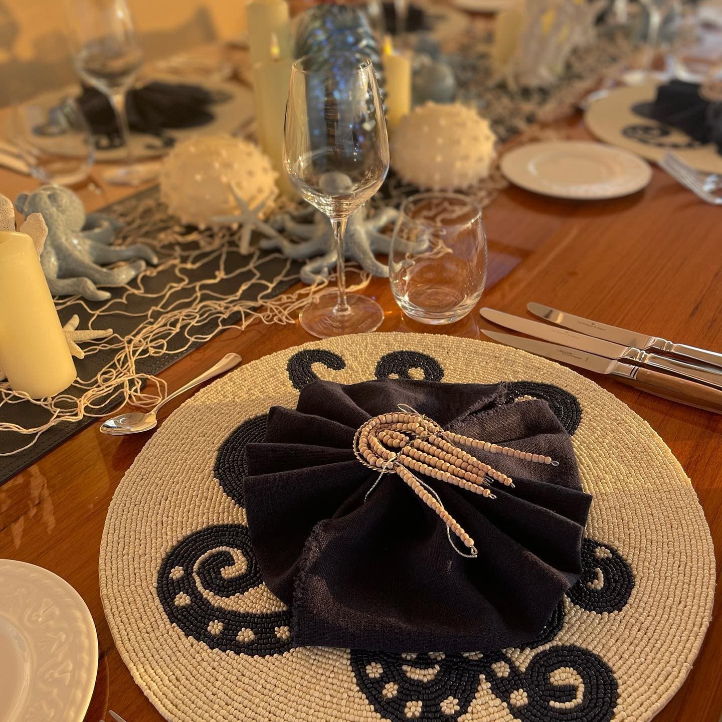 Evening place setting by candlelight, beaded charger and folded linen napkin