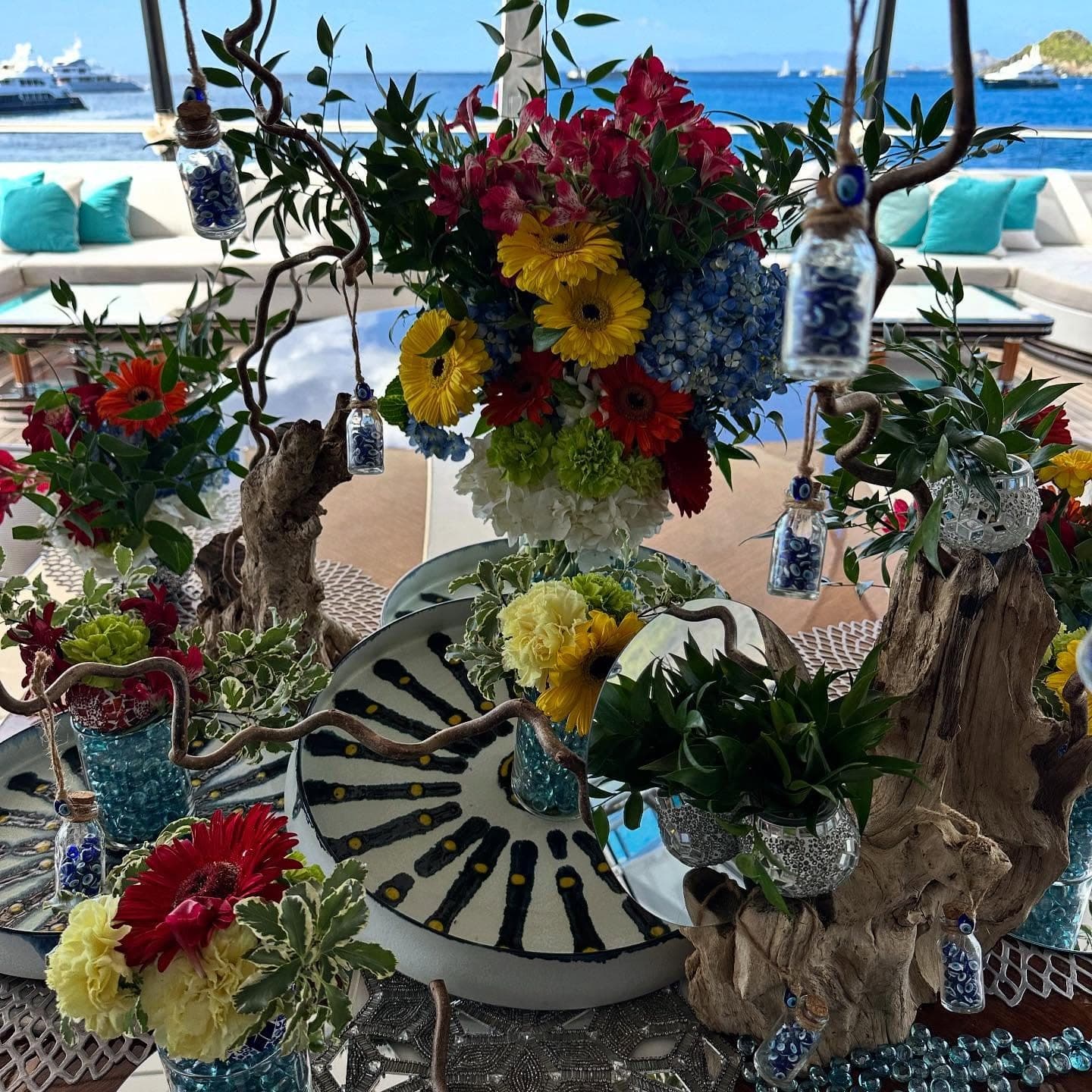 Flowers and hand-styled table detail on deck, harbour beyond