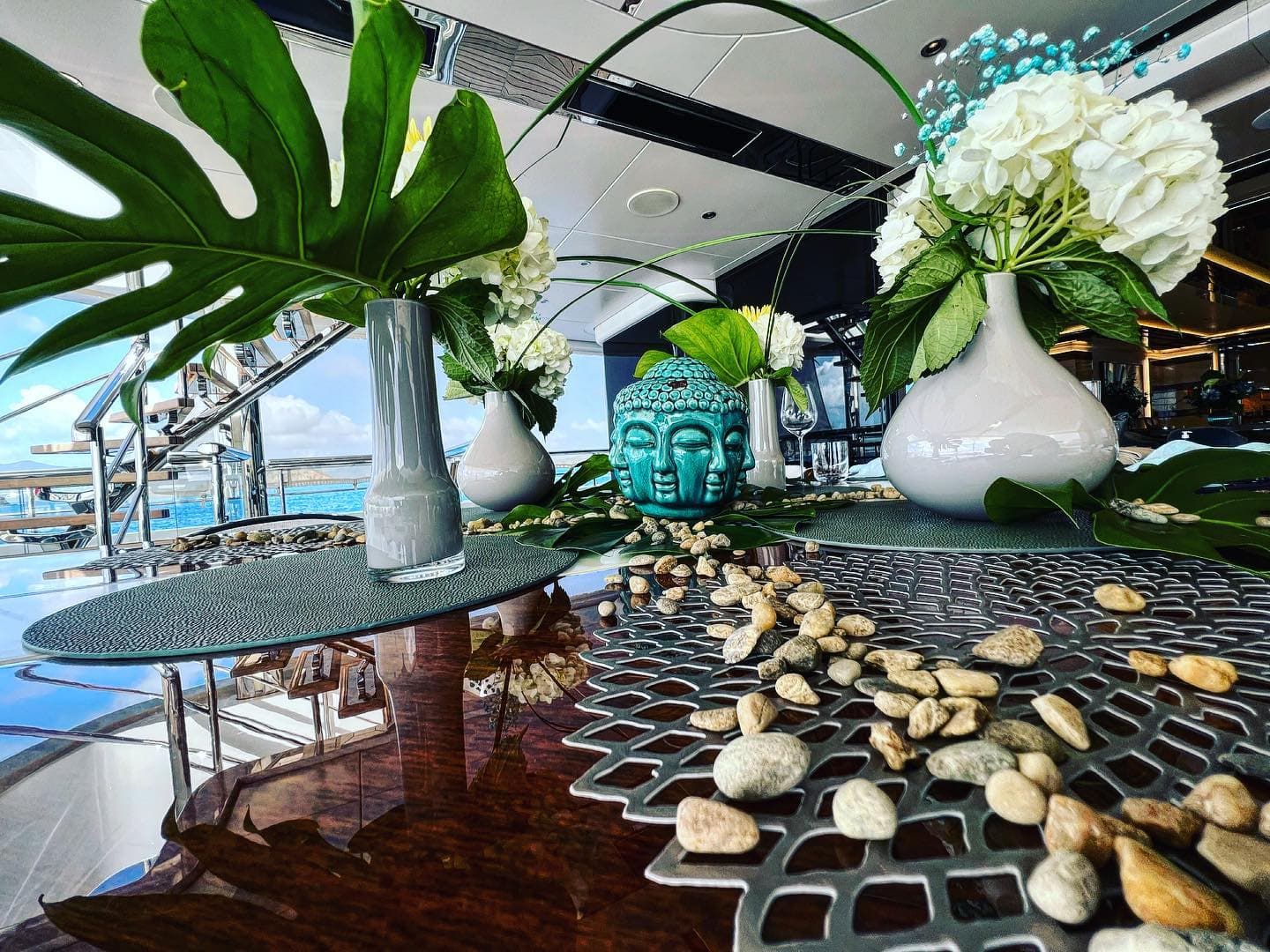 Interior dining table styled with hydrangeas and greenery, sea through the windows