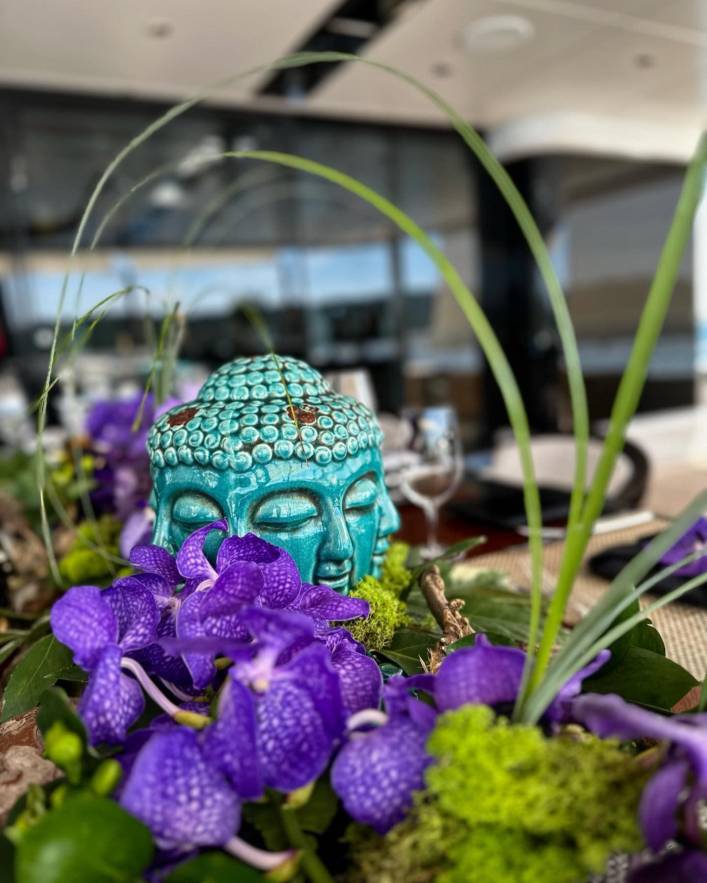 Vanda orchids and moss built around a ceramic centrepiece on the dining table