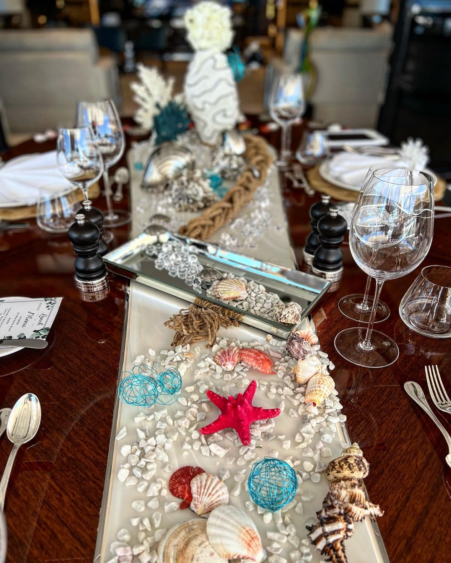 Lunch table dressed with shells, coral and a handwritten menu card