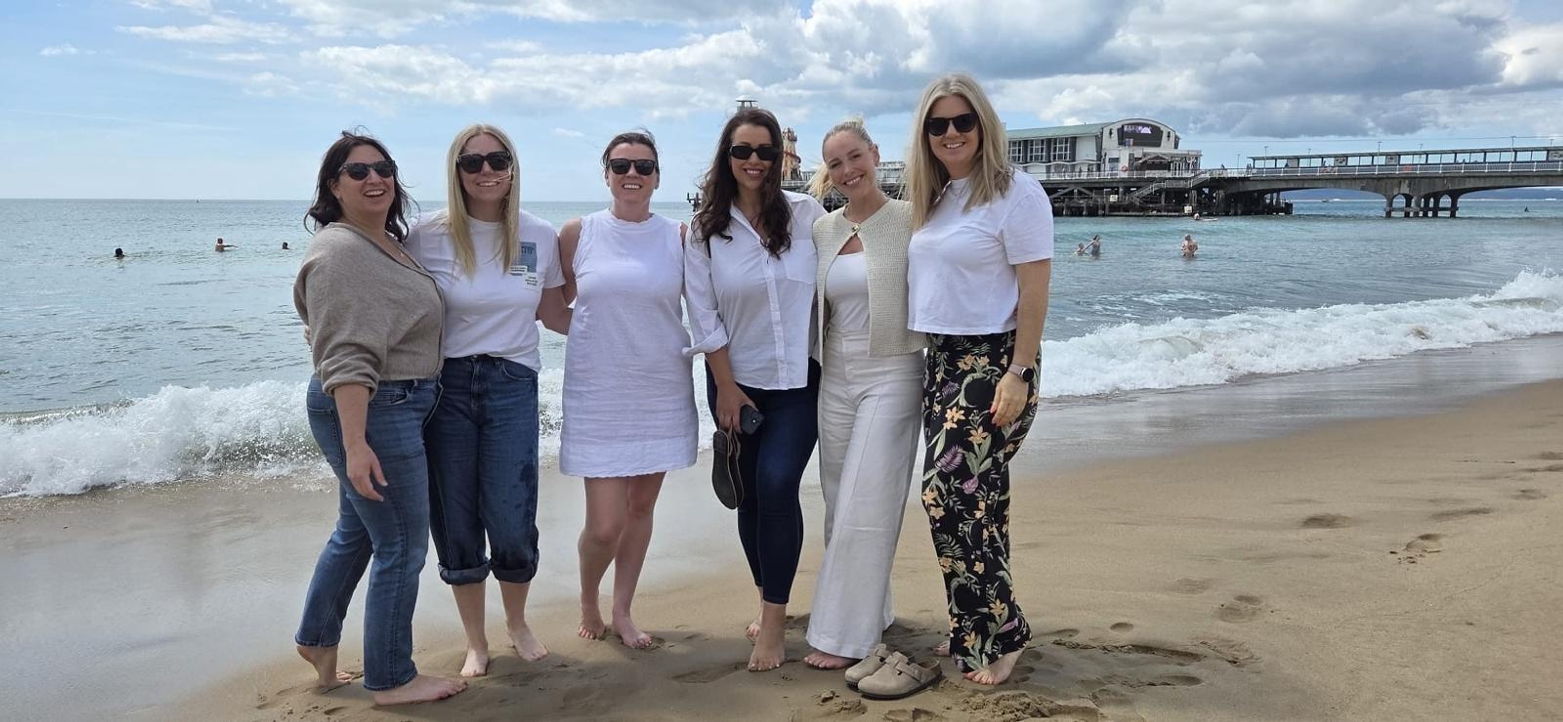 Six members of the Quay Group team at the water's edge with Bournemouth Pier behind them