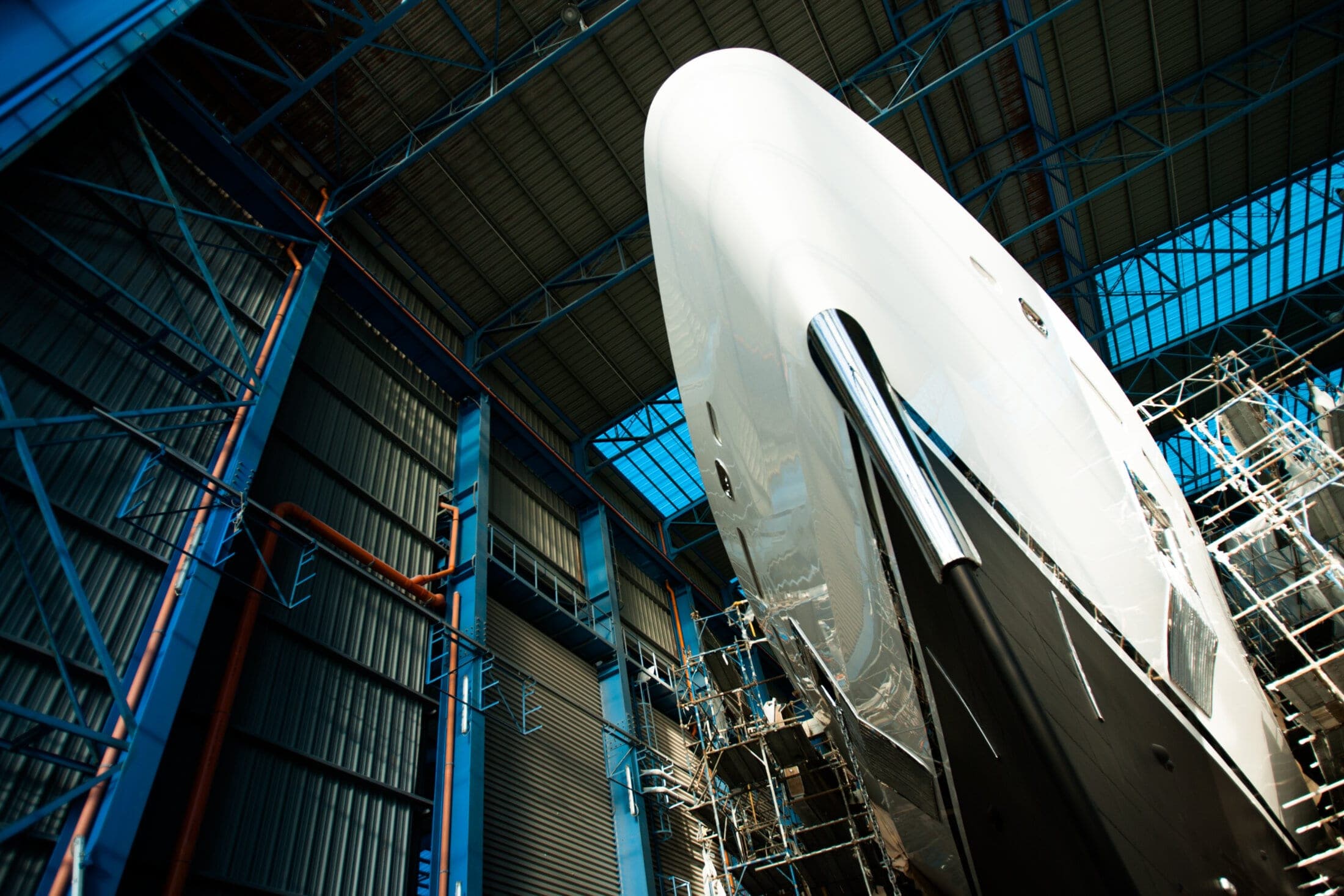 Superyacht under cover in a shipyard shed during refit